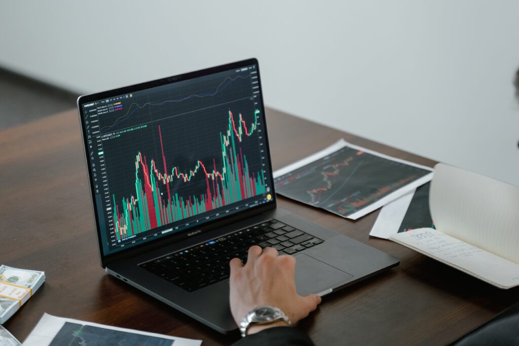 Male hand typing on a laptop with data displayed on the screen